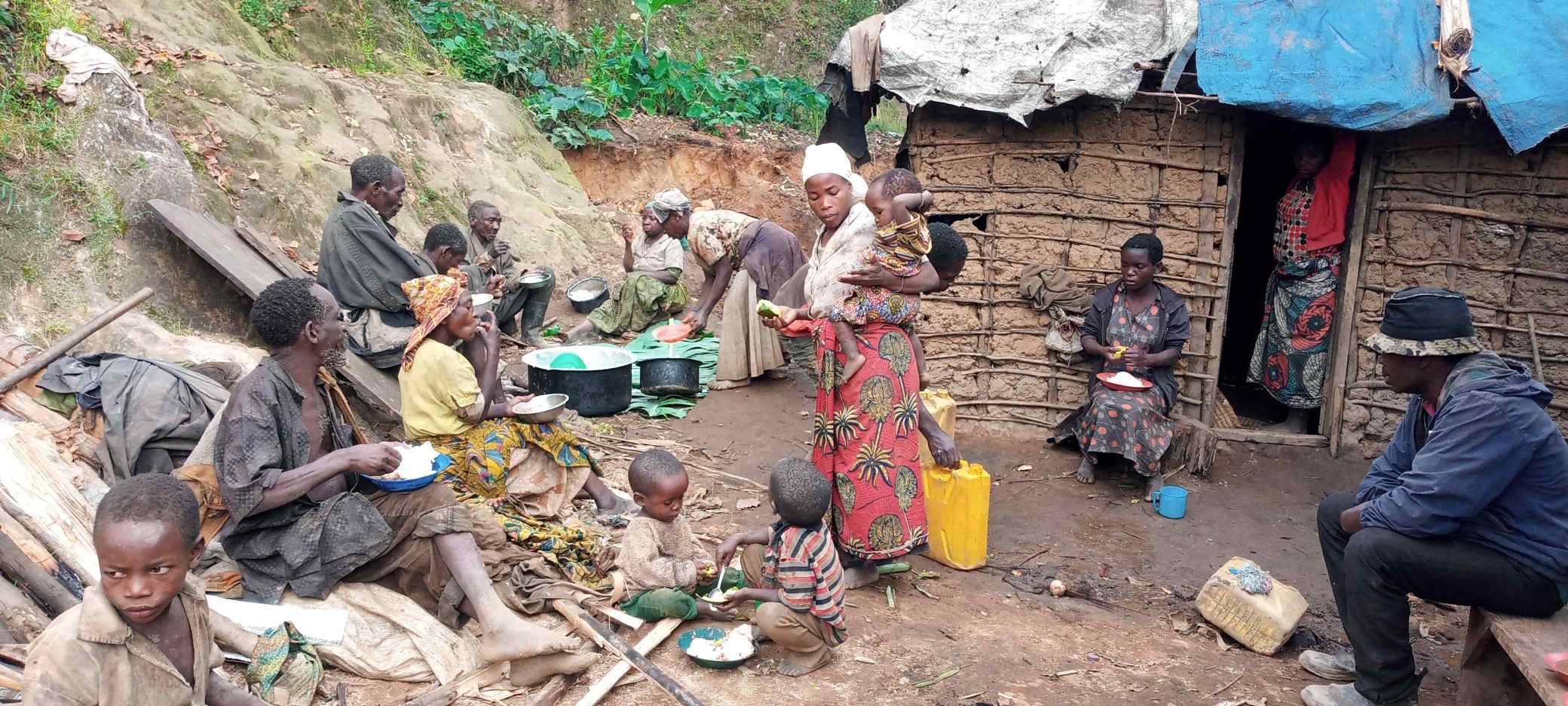 Batwa having lunch while the construction goes on